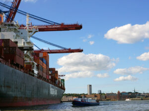 Containerschiff auf der Elbe im Hamburger Hafen, im Hintergrund Stadtsilhouette