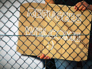 Pappschild mit Aufschrift Refuguees Welcome
