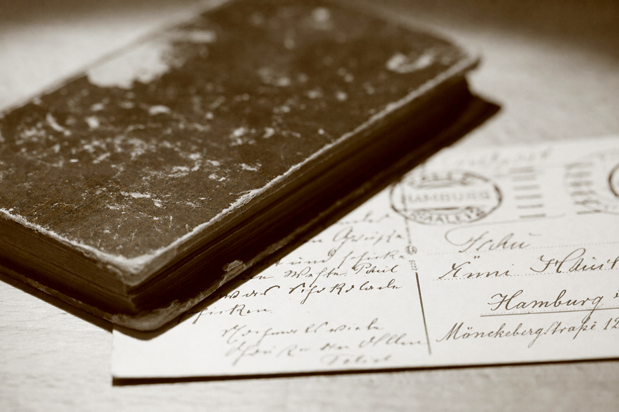 altes geschlossenes Tagebuch und historische Postkarte