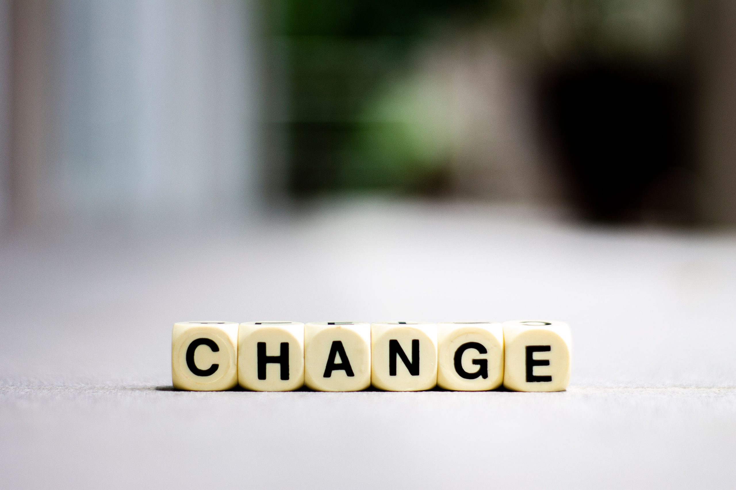 Nahaufnahme von Buchstabenblöcken, die 'Change' buchstabieren, symbolisiert Transformation und Wachstum.
